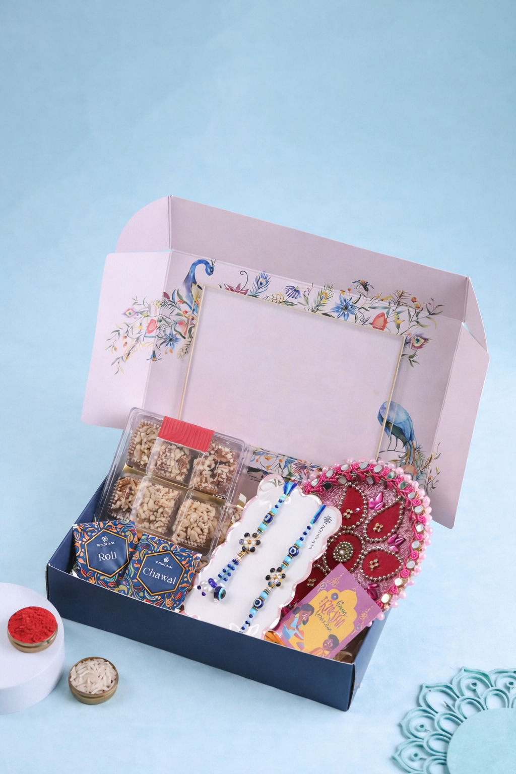 Premium Rakhi gift hamper with designer rakhis, baklava sweets, roli chawal boxes, decorative puja thali and festive gift packaging.